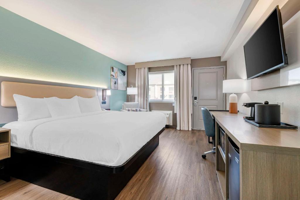 a hotel room with a large bed and a desk at Comfort Inn Sea World Area in San Diego