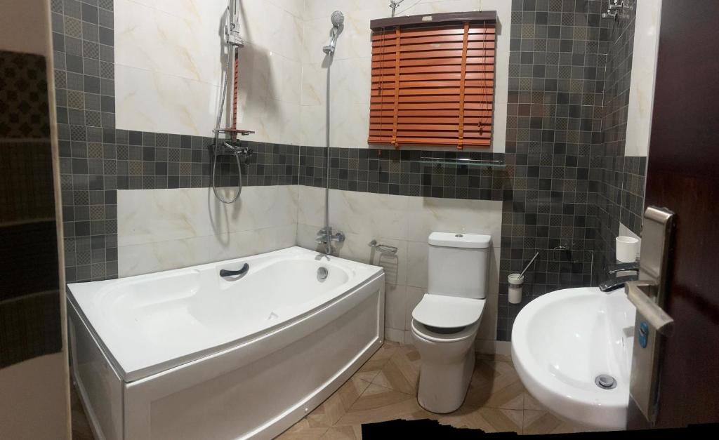 a bathroom with a tub and a toilet and a sink at Prime PH Home in Port Harcourt