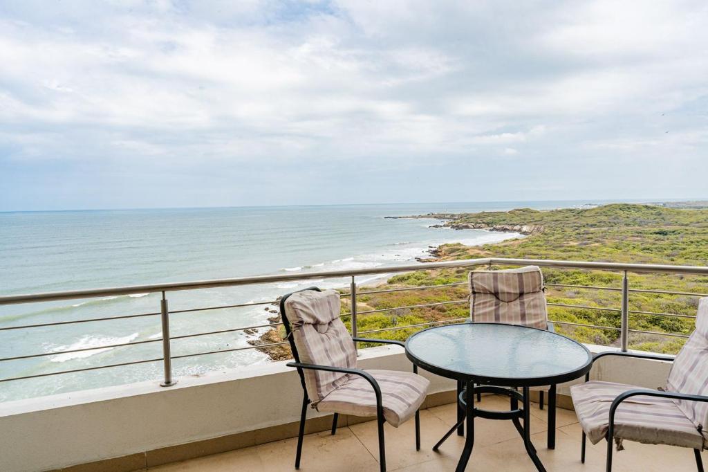 a balcony with a table and chairs and the ocean at APARTAMENTO EN VILLAMIL PLAYAS in Playas