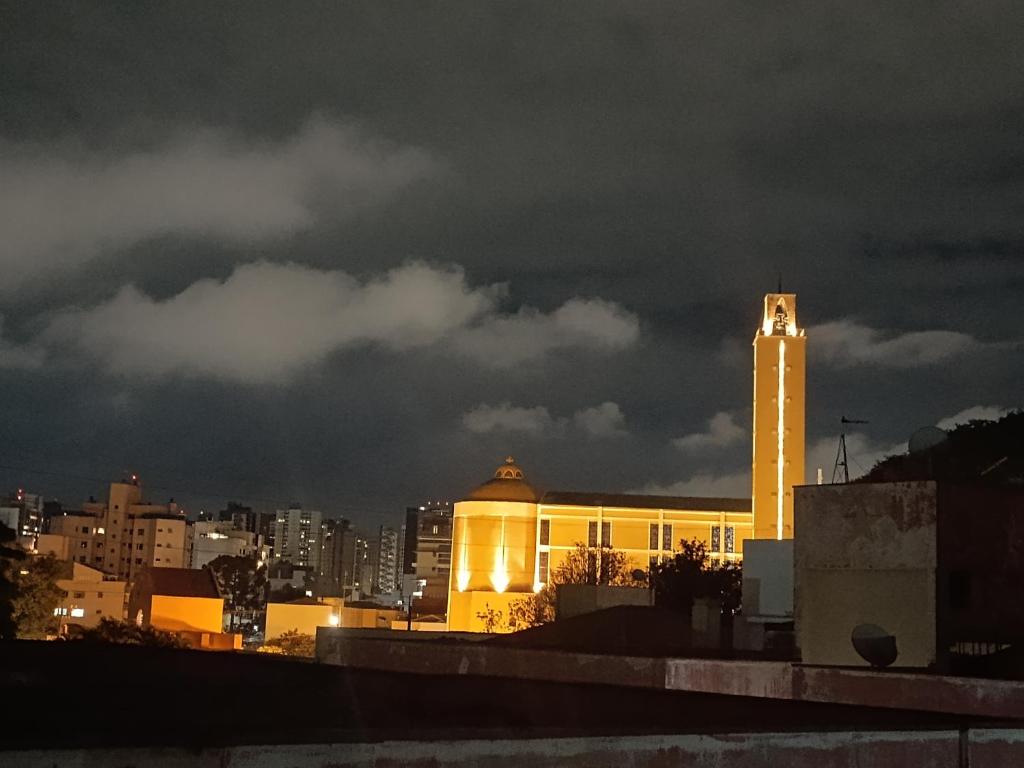 un edificio con una torre de reloj en una ciudad por la noche en Axel costa en Curitiba