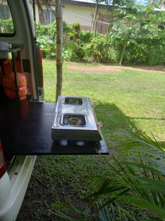 una estufa sentada en la puerta de un camión en Turtle Campervans Fiji, en Korotogo