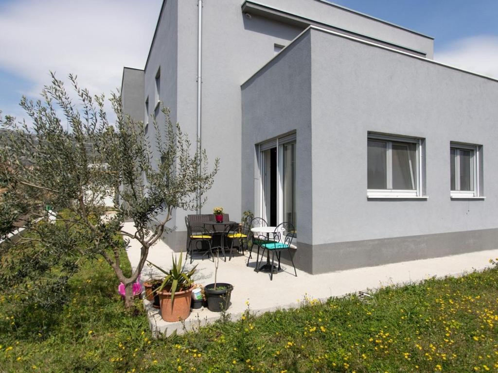 uma casa com um pátio com uma mesa e cadeiras em Apartments with a parking space Kastel Stari, Kastela - 22590 em Kaštela