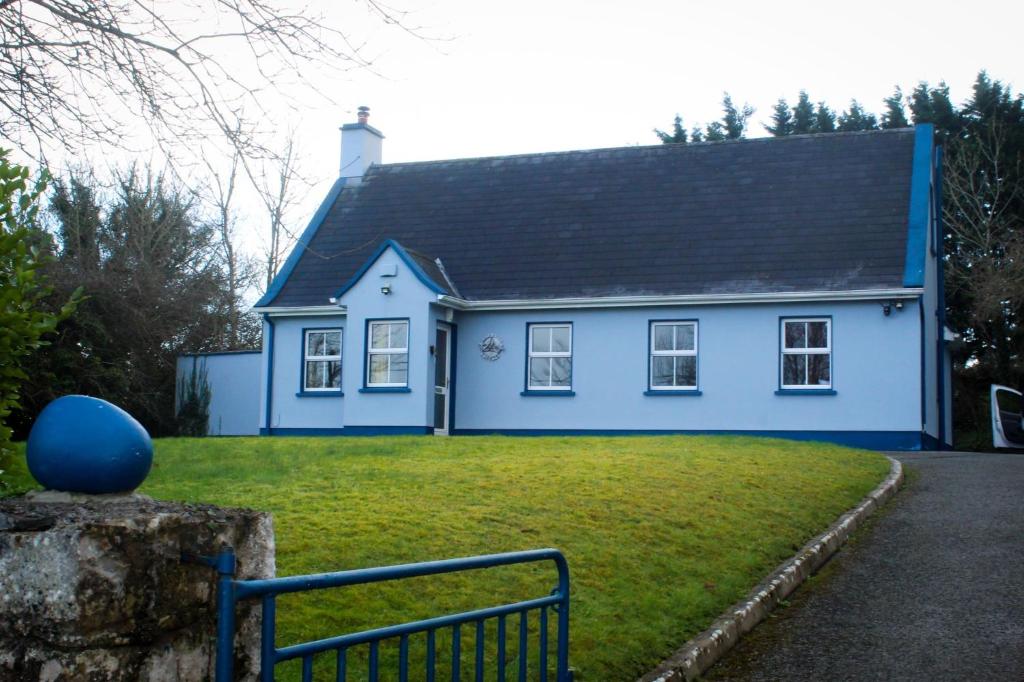 a blue house with a black roof at Riverside Cottage in the Burren in Corrofin