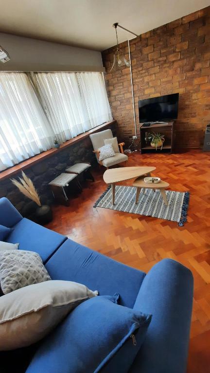 Casa Nevenka في ميندوزا: غرفة معيشة مع أريكة زرقاء وطاولة