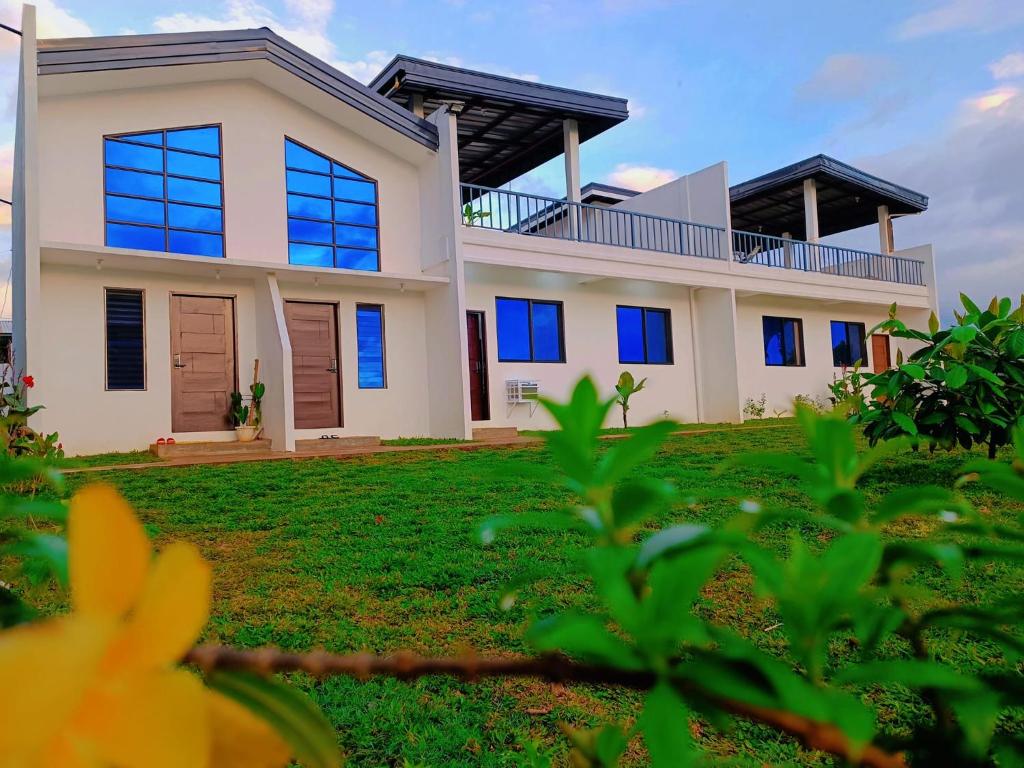 una casa con finestre blu e erba verde di Casa Concetta Resort a Manolo Fortich