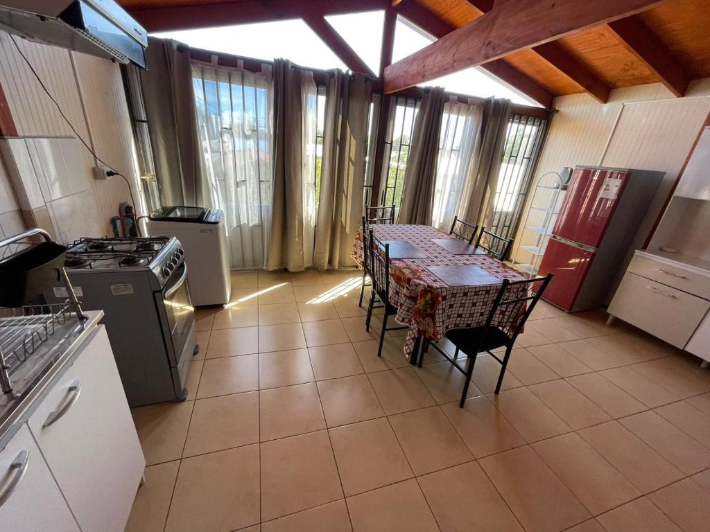 a kitchen with a table with chairs and a stove at Casa Amoblada en Coronel 2 in Coronel
