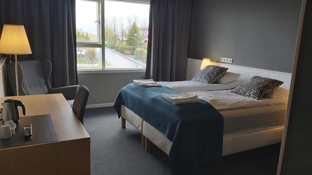 Un pat sau paturi într-o cameră la Hotel Kanslarinn Hella