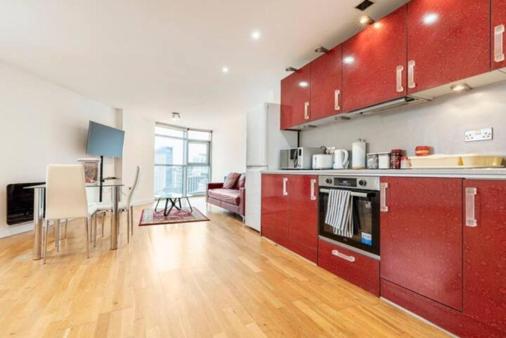 una cucina con armadi rossi e un soggiorno di Cardiff city apartment 2 a Cardiff