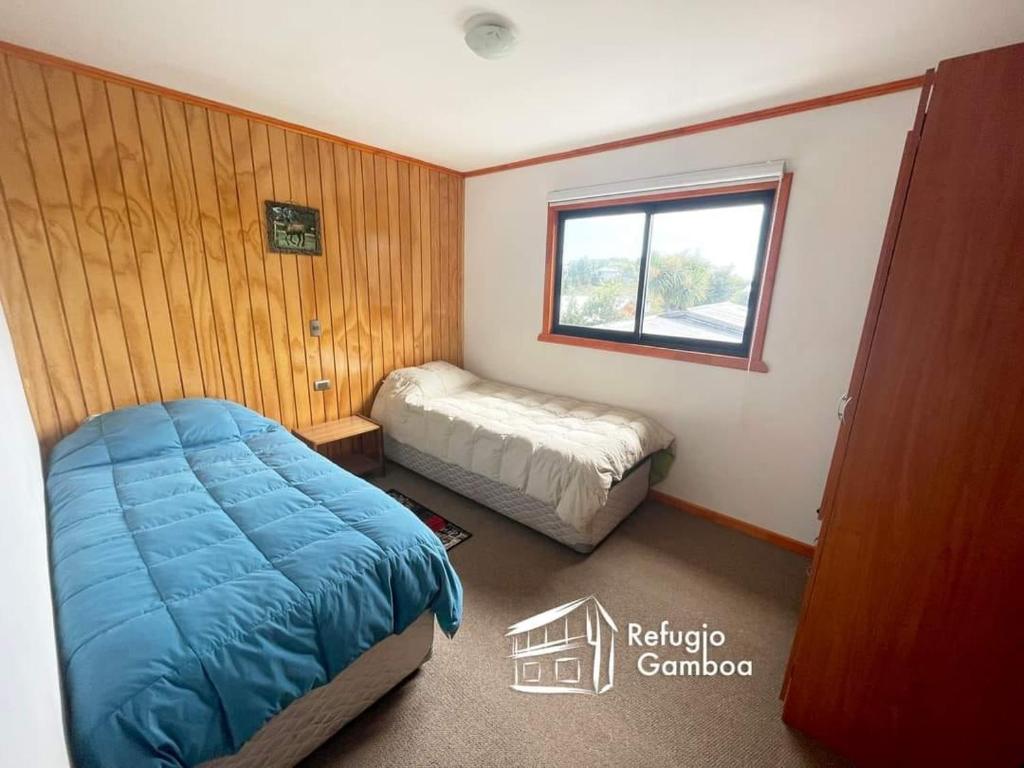 a bedroom with a bed and a window in it at REFUGIO GAMBOA in Castro
