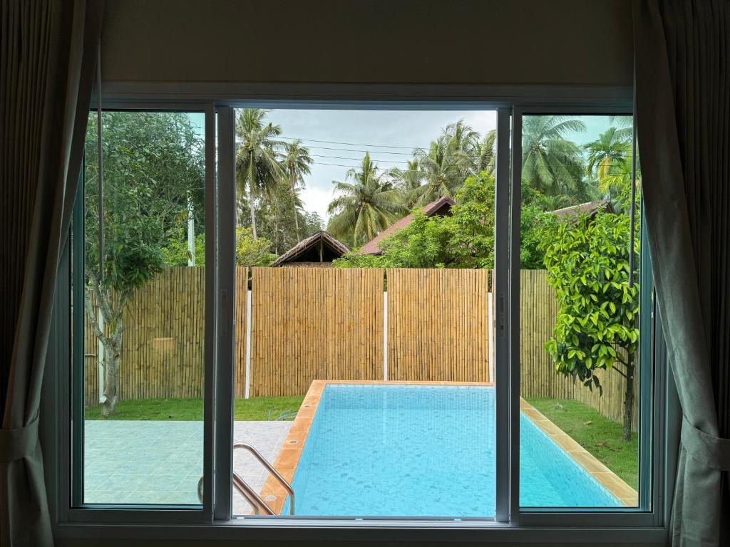 - une vue sur la piscine depuis la fenêtre dans l'établissement Two bedroom Villa Mango, à Ko Pha Ngan
