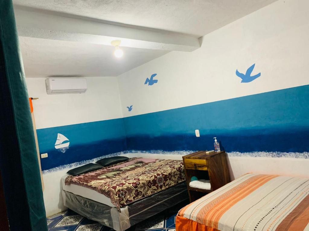 a bedroom with two beds and blue walls at Cuarto Cactus in El Paredón Buena Vista
