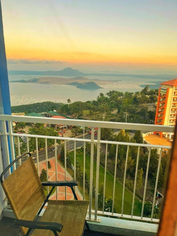 a balcony with a bench and a view of the ocean at JT Tagaytay Suites in Tagaytay
