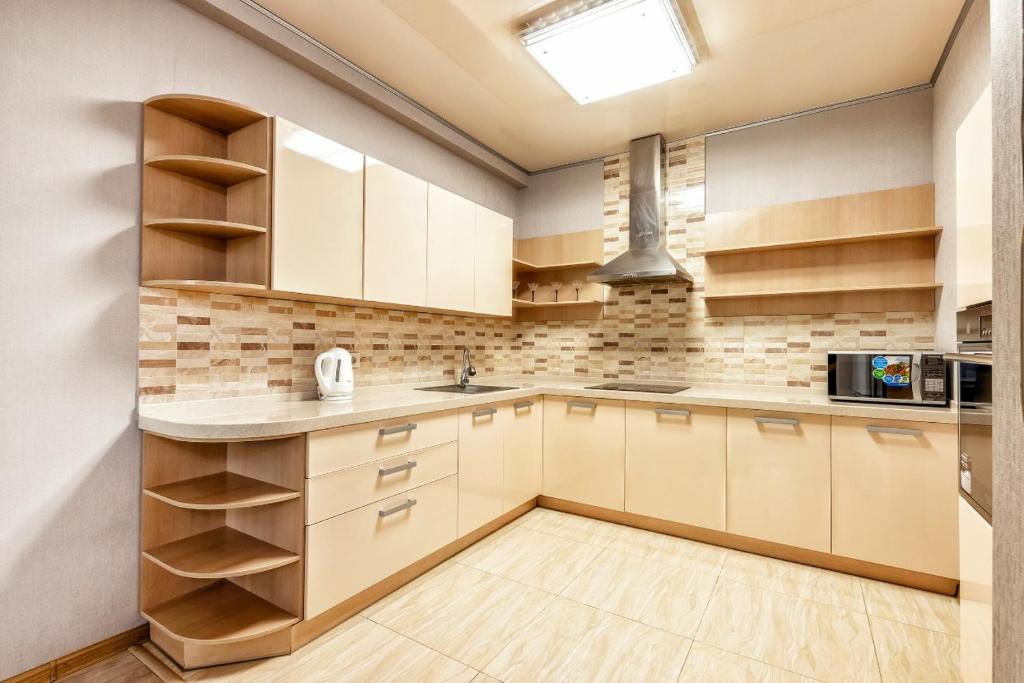 a kitchen with white cabinets and a sink at Замок столицы in Astana