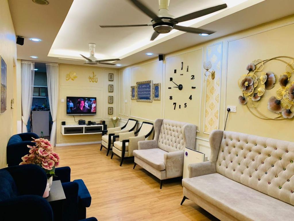 uma sala de espera com sofás e um relógio na parede em zam homestay kulim perdana hitech utk Msliim shj em Kulim