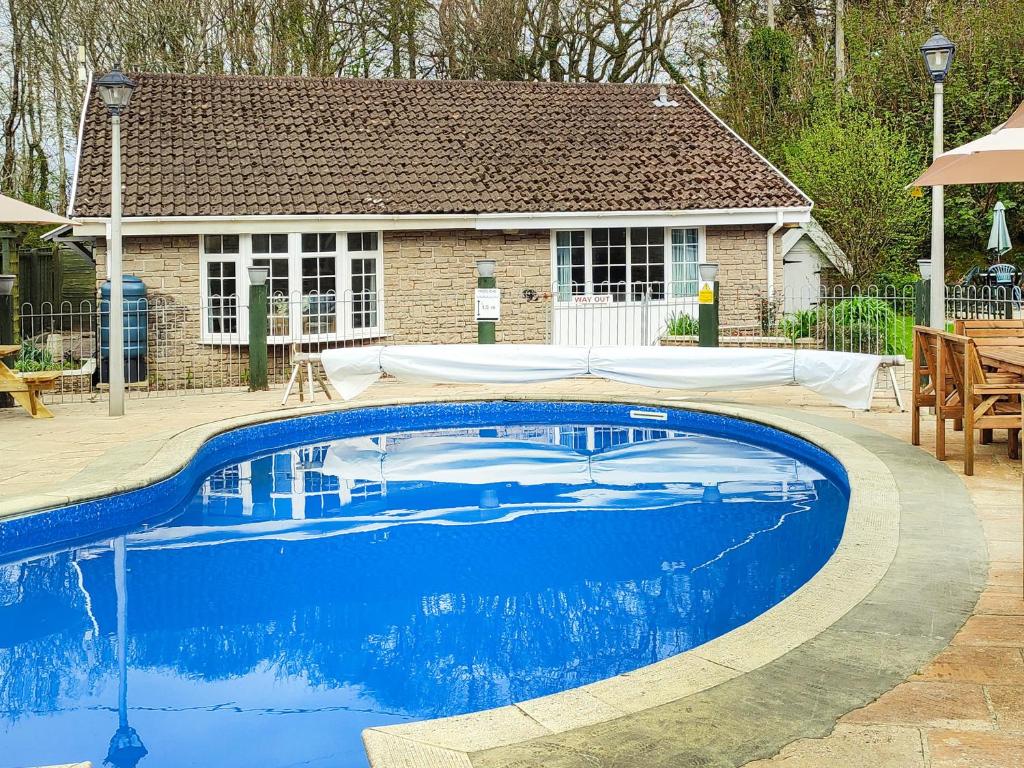 una gran piscina azul frente a una casa en Bank Voles Nest - Uk45199, en Trelaske