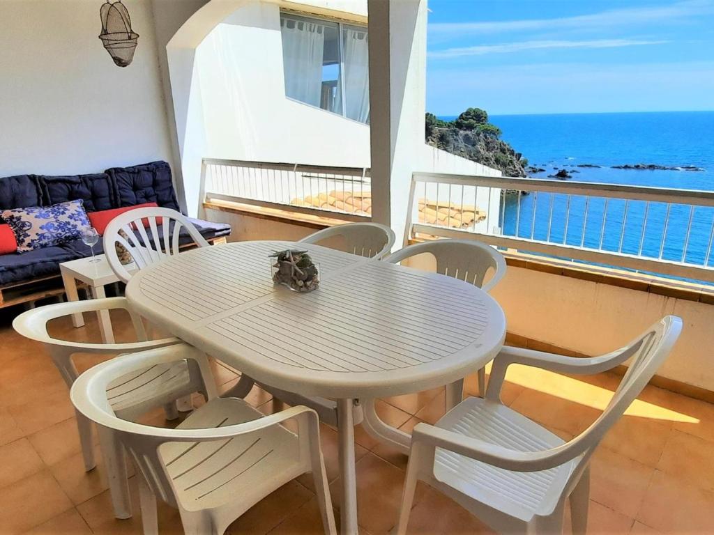 una mesa y sillas blancas con vistas al océano en Apartamento Llançà, 3 dormitorios, 8 personas - ES-170-69, en Llançà