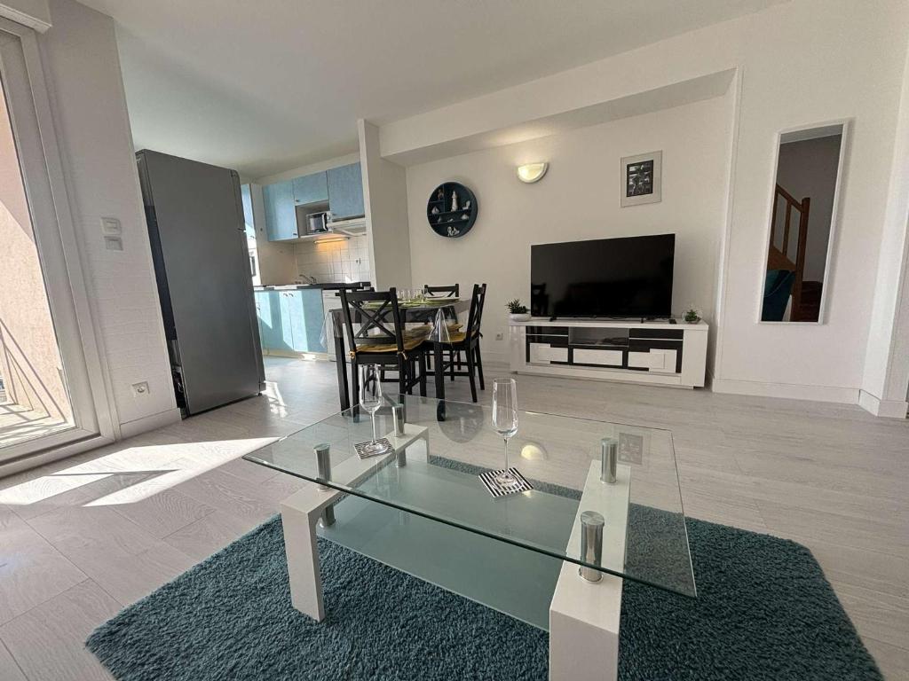 - un salon avec une table en verre et une salle à manger dans l'établissement Spacieux appartement 2 chambres avec parking à Rochefort - FR-1-246B-50, à Rochefort