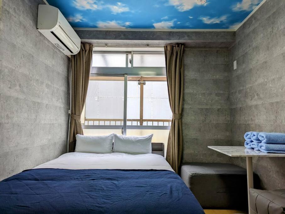 a bedroom with a blue bed and a window at Home cruise西小山 in Tokyo
