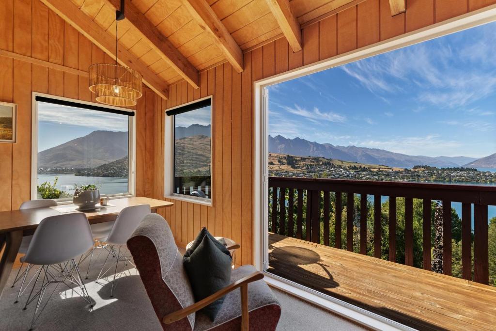 a room with a balcony with a table and chairs at The Lookout in Queenstown