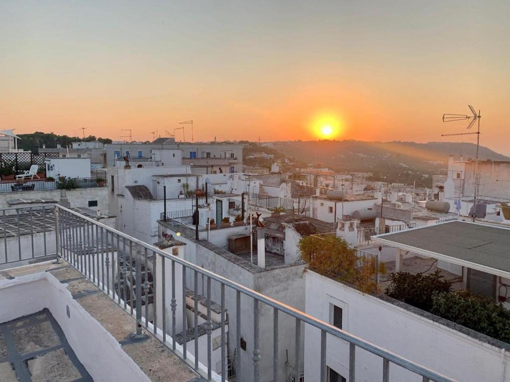 een balkon met uitzicht op de stad bij zonsondergang bij Dimora le Picciose in Ostuni
