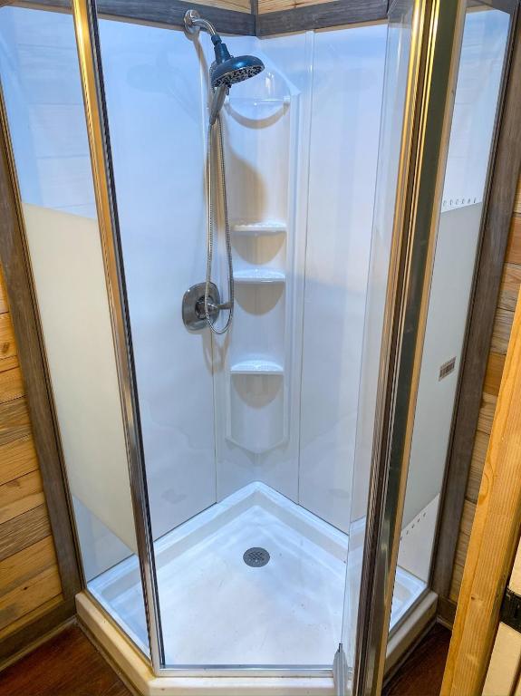 una doccia con una porta in vetro in un bagno di Tiny House Oasis Nature Escape Unit A a Nacogdoches