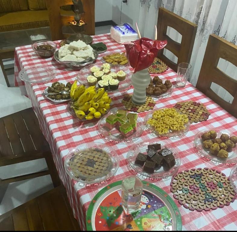 una mesa con un mantel a cuadros rojo y blanco en Himasha guest en Mirissa