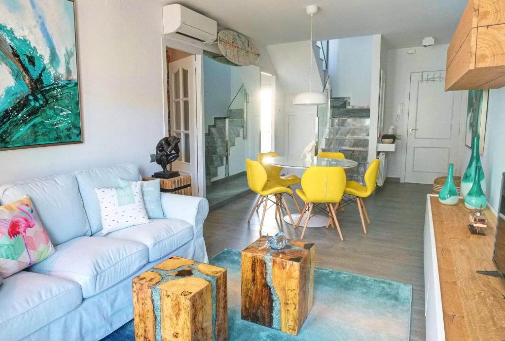 ein Wohnzimmer mit einem Sofa und einem Tisch in der Unterkunft Beachstyle Penthouse by Hello Homes Sitges in Sitges