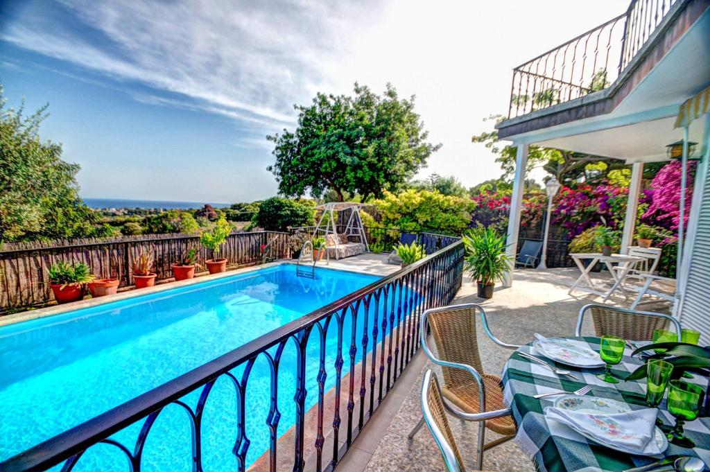 錫切斯的住宿－Can Ferran by Hello Homes Sitges，一个带桌椅的阳台的游泳池