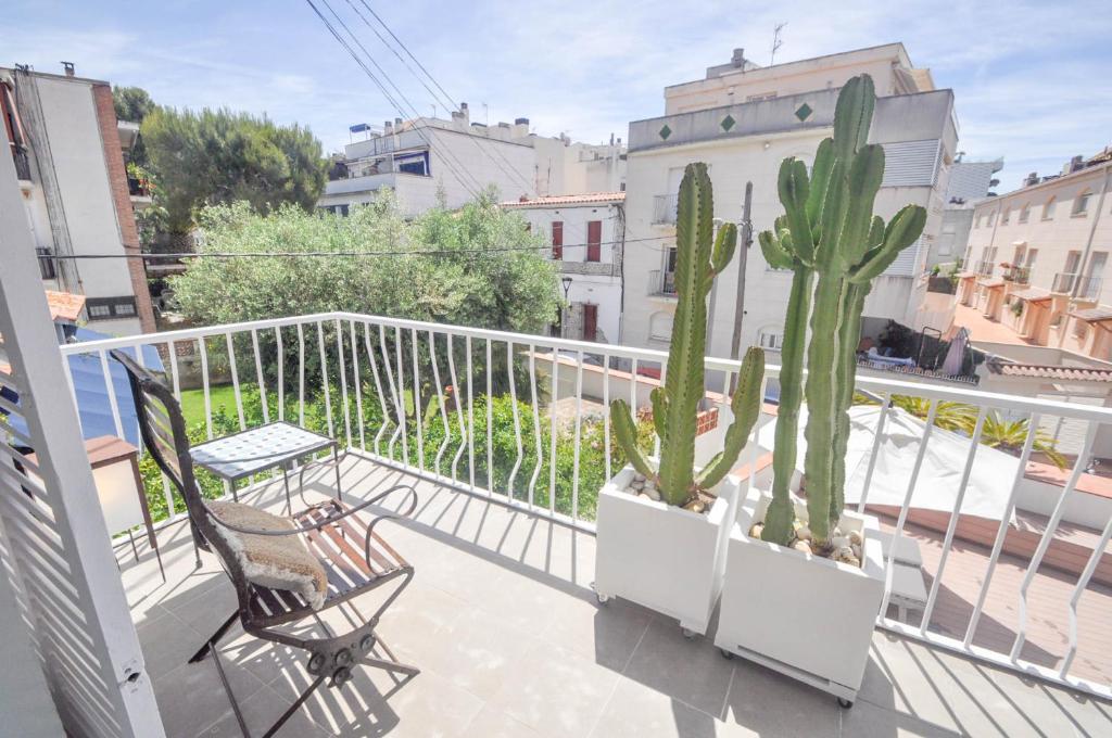einen Balkon mit zwei Stühlen und einem Kaktus darauf in der Unterkunft The Luxor Apartment by Hello Homes Sitges in Sitges