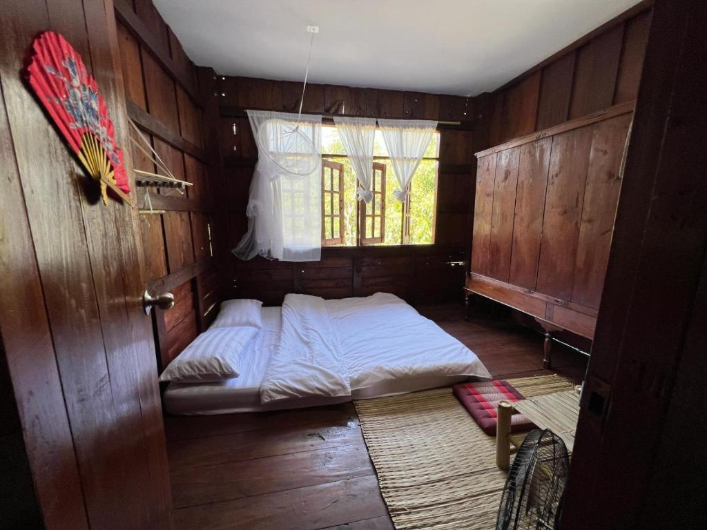 a bed in a wooden room with a window at Eden Farmstay CNX 
