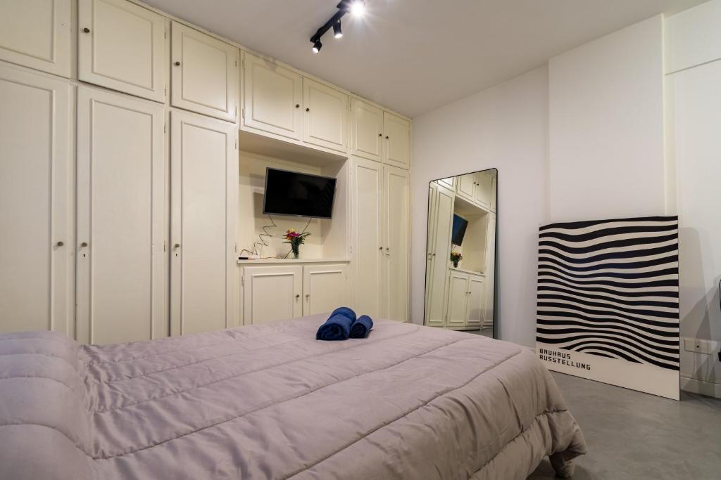 a bedroom with a large bed with blue shoes on it at Apartamento zona Embajada USA - Plaza Italia by Debarrio Aparts in Buenos Aires