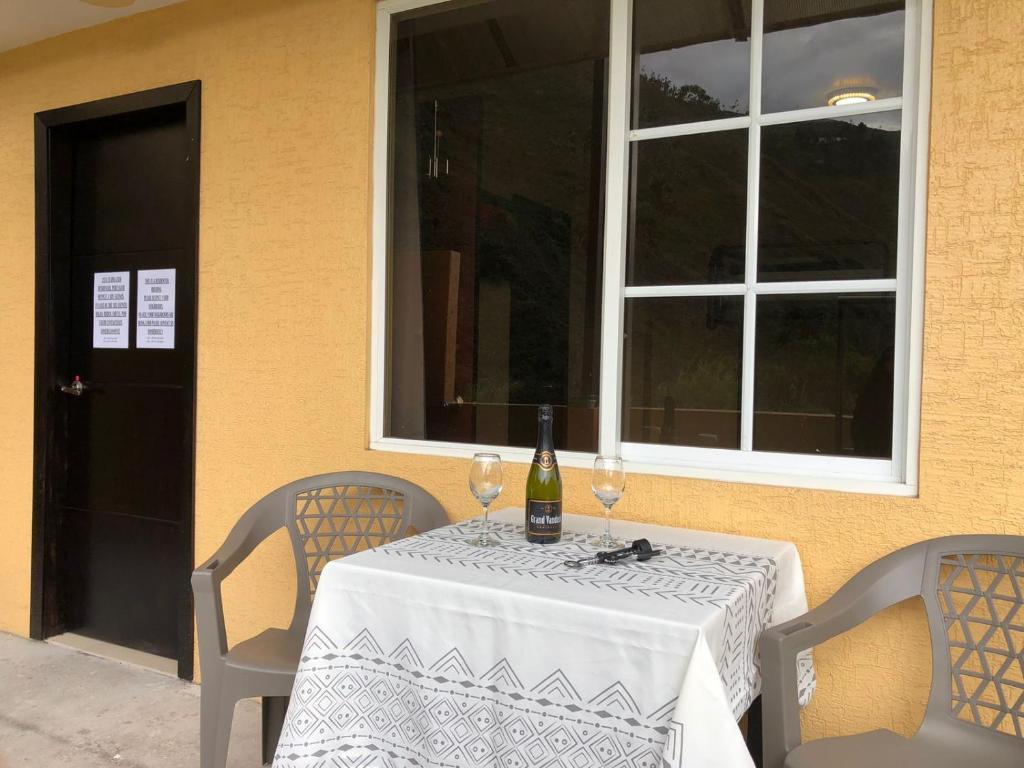 a table with a bottle of wine and two glasses at Mini Apartment with terrace in Baños