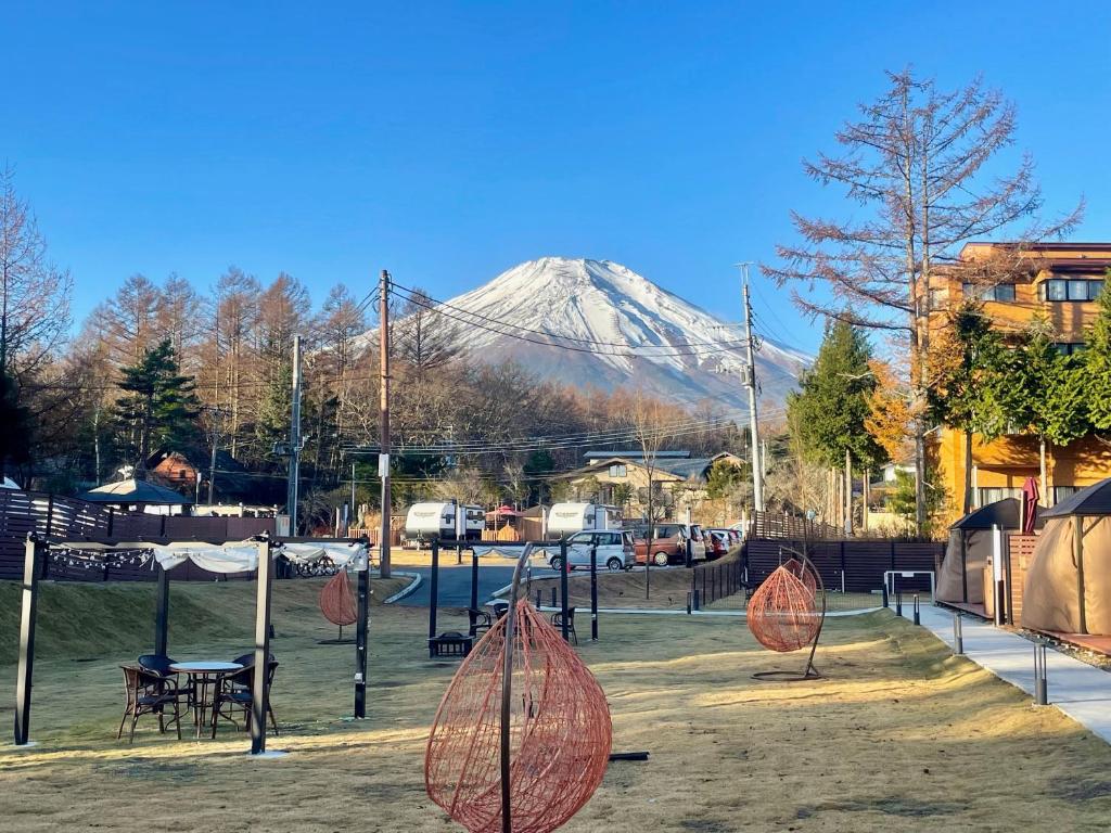 a snow covered mountain in the background of a park at Gramercy Village 山中湖 Glamping &Sauna in Yamanakako