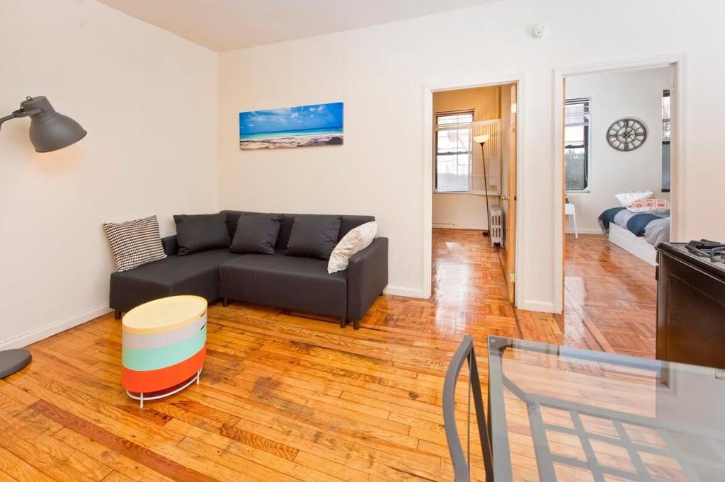 een woonkamer met een bank en een tv bij 102-2A Specious 2BR Best Value Near Cntrl Park in New York