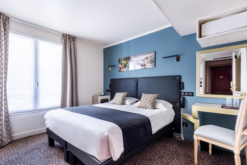 a hotel room with a bed and a chair at Hotel Louvre Sainte Anne in Paris