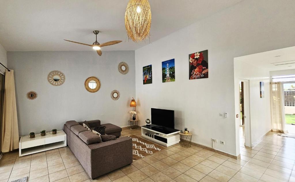 sala de estar con sofá y TV en House in a private residential area en Paea