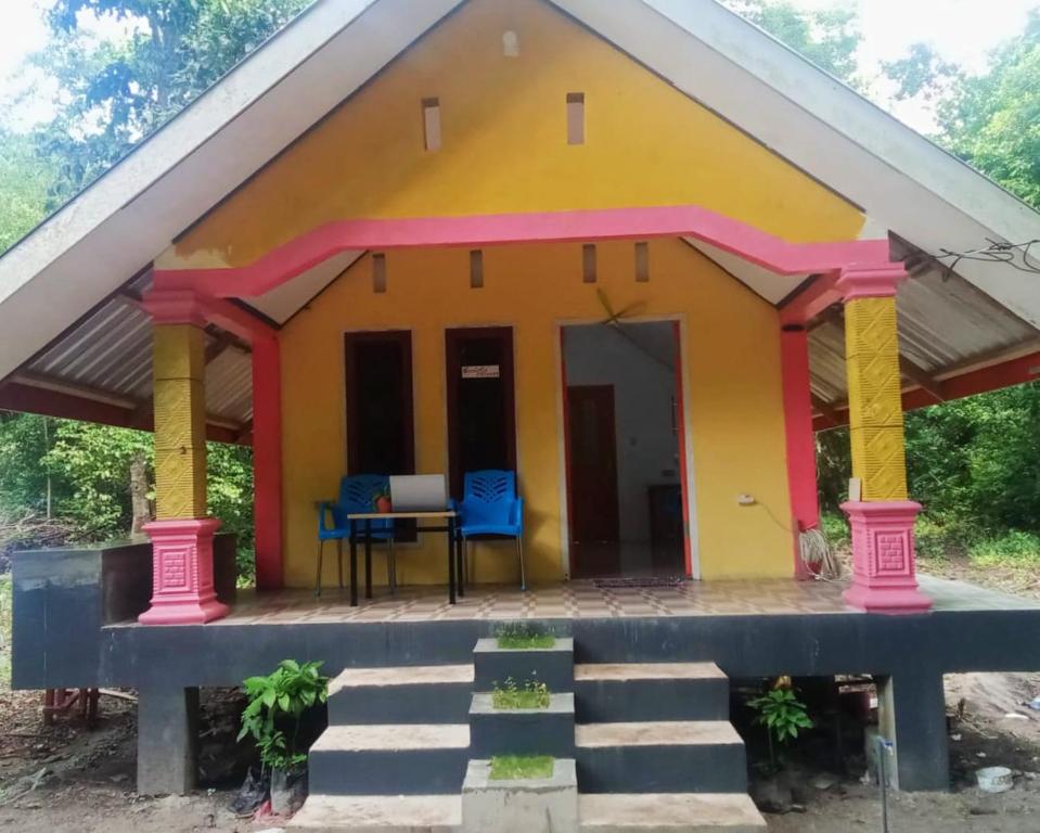 ISABELLA COTTAGE في لانغور: منزل صغير مع طاولة وكراسي زرقاء