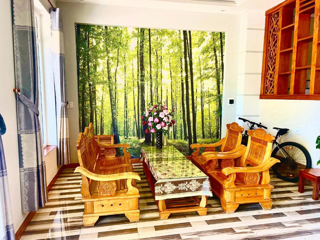 Phú QuýにあるKhách Sạn Chấn Phú Quýの椅子とテーブル、木の窓が備わる客室です。