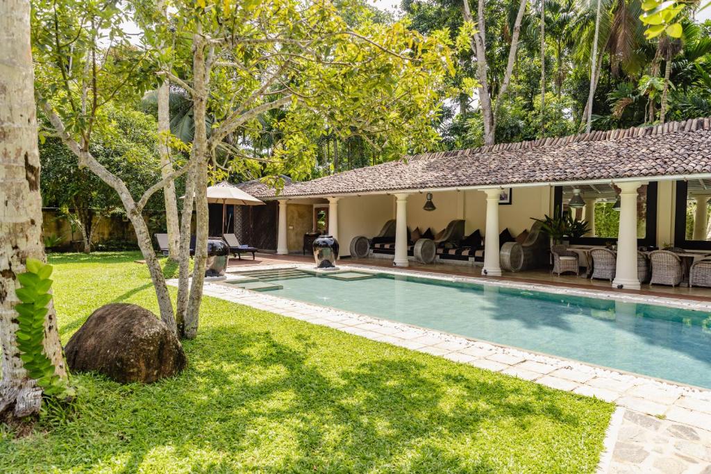 a swimming pool in the yard of a house at Pedlar's Manor in Talpe