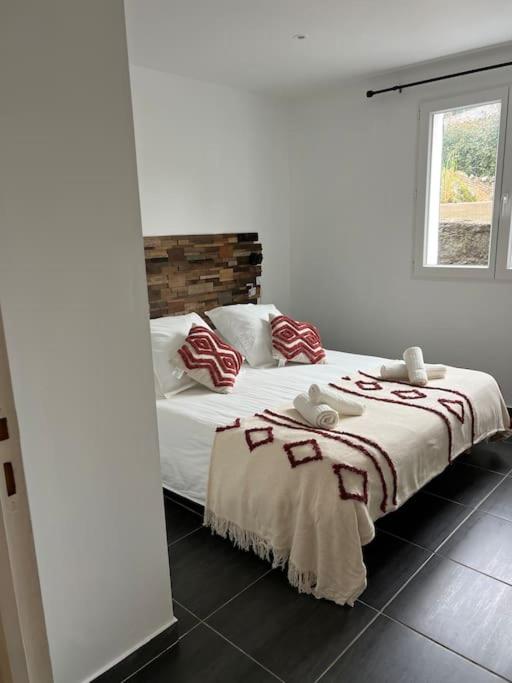 une chambre avec un grand lit avec des oreillers rouges et blancs dans l'établissement A nepita di porto vecchio***, à Porto-Vecchio