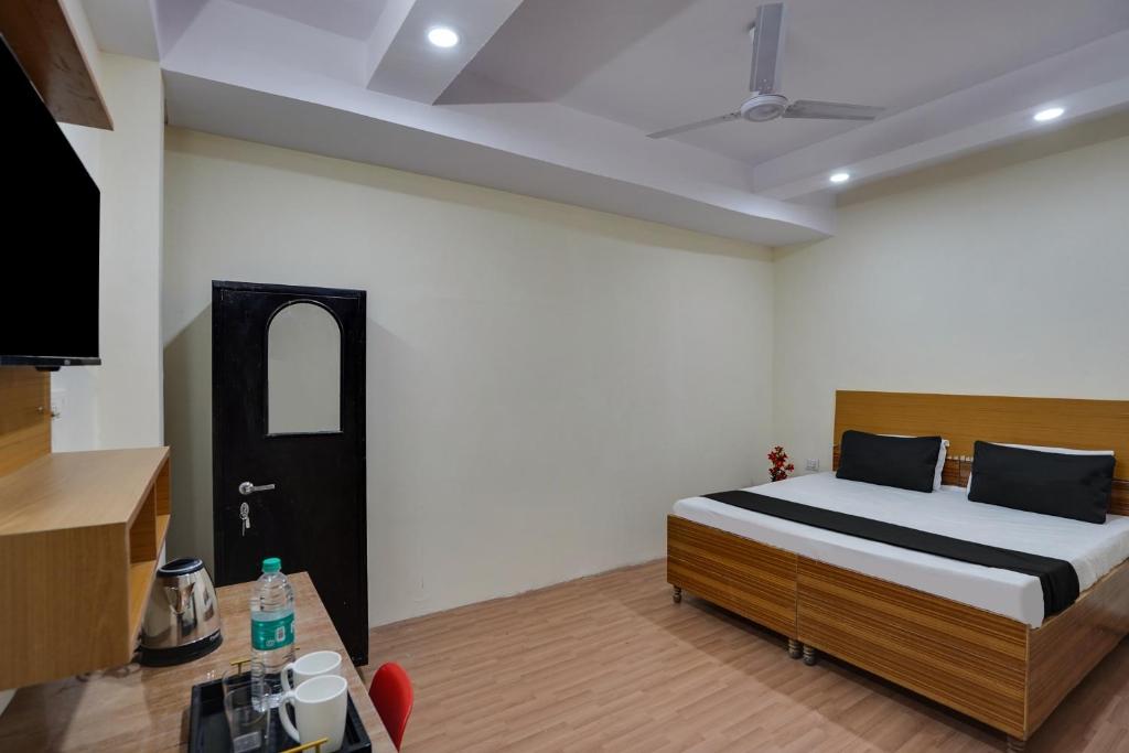 a bedroom with a bed and a table in a room at OYO Lotus Inn in New Delhi