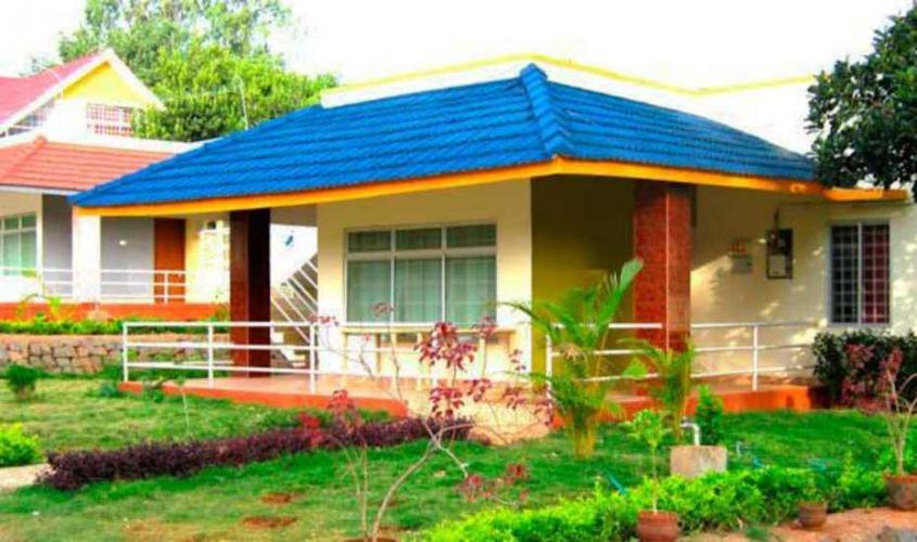 a house with a blue roof and a yard at Peters Park in Yelagiri