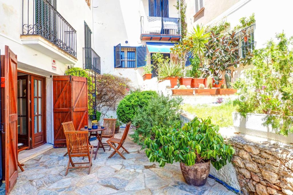 une terrasse avec une table, des chaises et des plantes dans l'établissement Charming House by Hello Homes Sitges, à Sitges