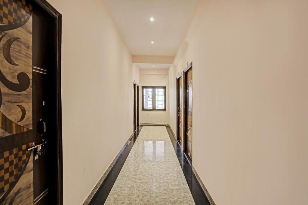 a corridor of a hallway with white walls and doors at OYO Flagship Krishna Galaxy in Kānpur