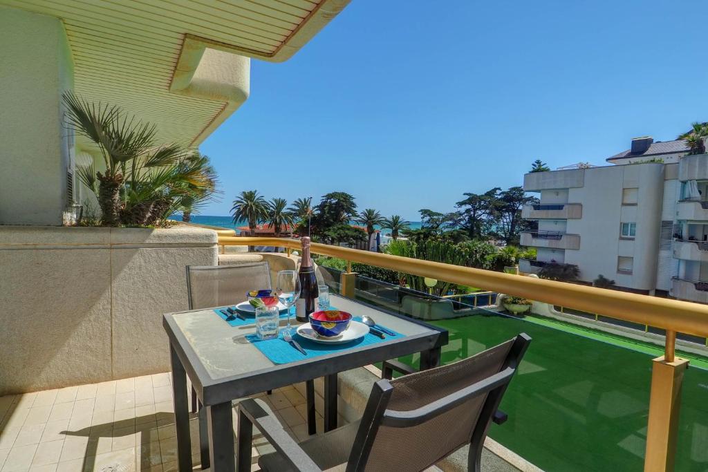 einen Tisch und Stühle auf einem Balkon mit Meerblick in der Unterkunft Mediterraneo Seaview Apartment by Hello Homes Sitges in Sitges