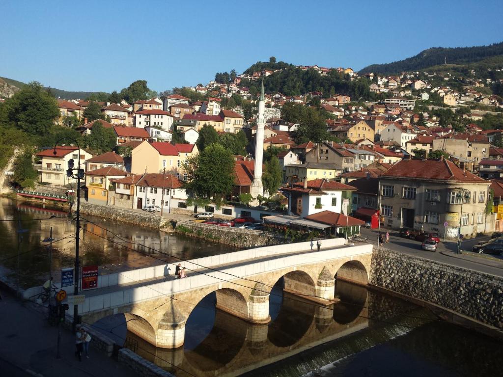 un puente sobre un río con una ciudad al fondo en Toplik, en Sarajevo