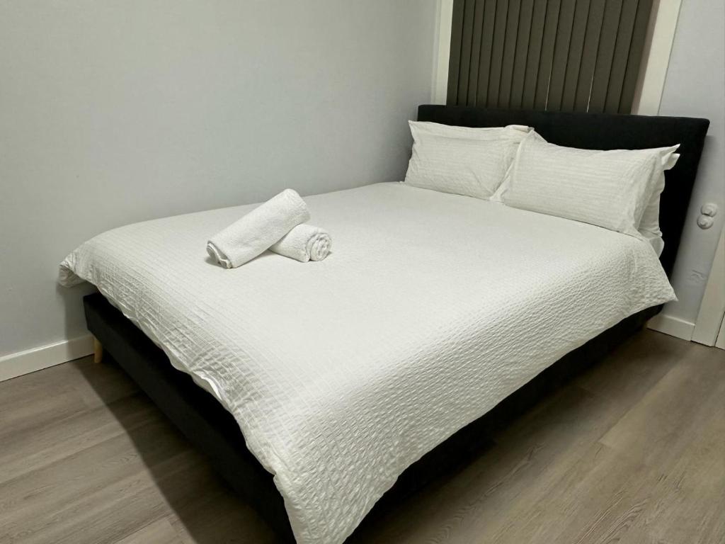 a bed with two rolled towels on top of it at ROOM - BEXLEY NORTH in Sydney