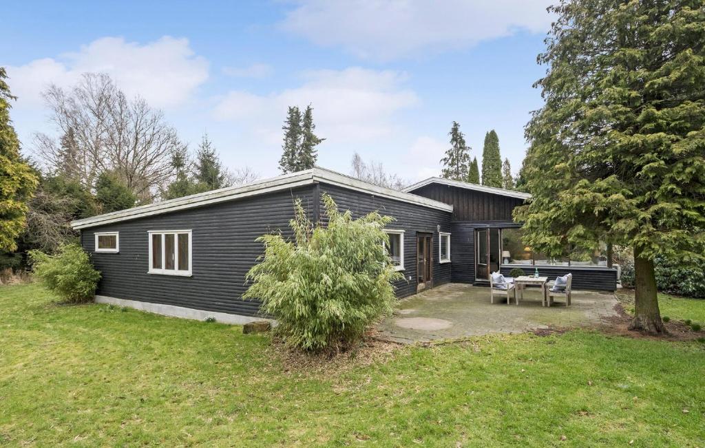 una casa negra con una mesa de picnic en un patio en Stunning Home In Hornbk With Kitchen, en Hornbæk