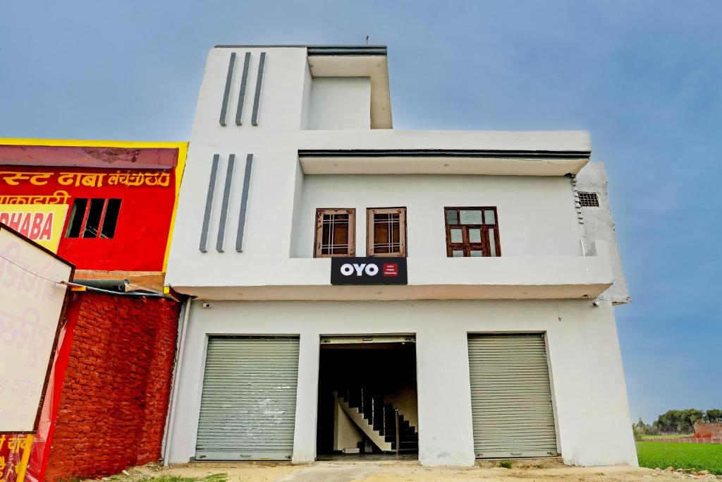um edifício branco com uma porta aberta em OYO The Happy Homestay em Moradabad