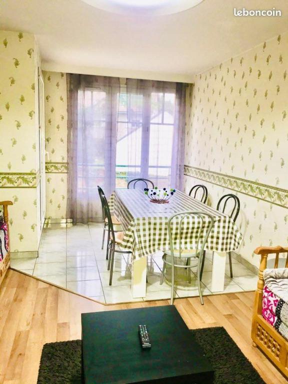 une salle à manger avec une table et des chaises et une fenêtre dans l'établissement Grand Appartement proche d’Orly et Paris, à Ris-Orangis